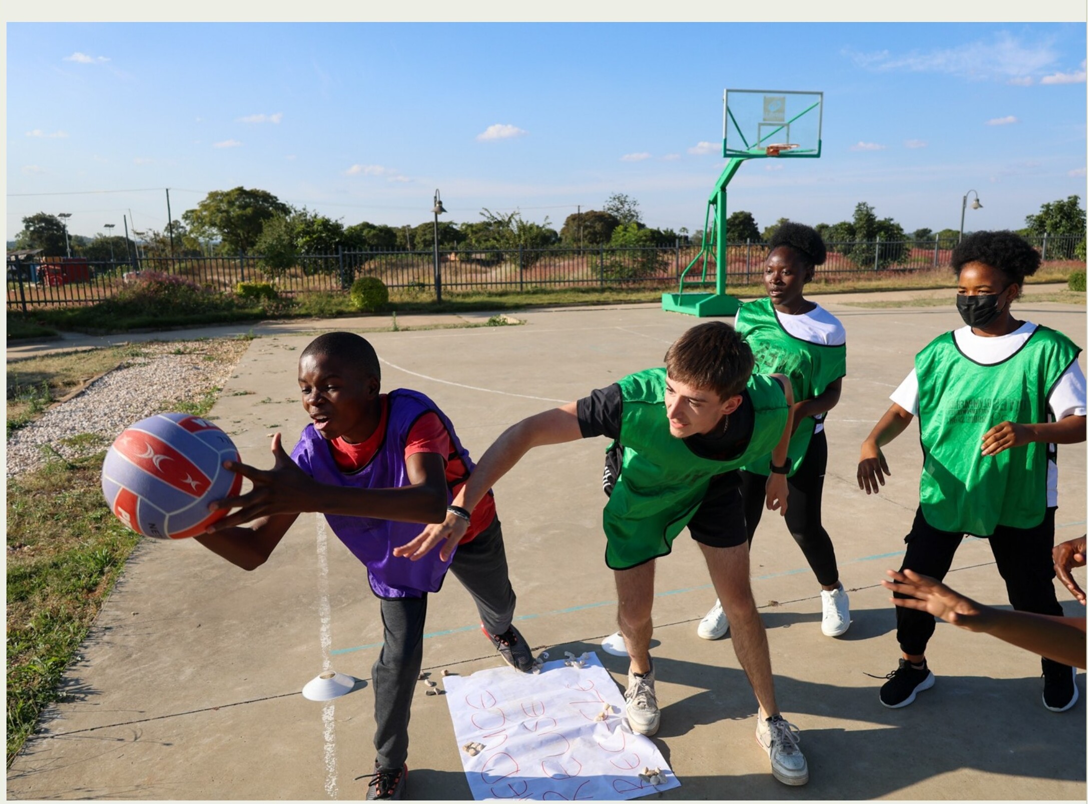 Young Climate Game Changers ambassadors playing basketball as part of a sport-based climate advocacy activity in Lusaka, Zambia